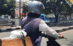 Seorang pengendara motor melaju di jalan Kota Bandung siang hari. (29/10/2024) (Sumber: Khalidullah As Syauqi)