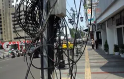 Warga melintas di dekat kabel yang ada di Jalan Braga, Kota Bandung. (Sumber: Ayobandung | Foto: Irfan Al Faritsi)