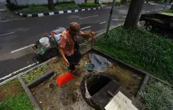 Warga mengambil air sumur yang berada di trotoar Jalan Cipaganti, Kelurahan Pasirkaliki, Kecamatan Cicendo, Kota Bandung. (Sumber: Ayobandung | Foto: Irfan Al Faritsi)