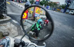 Salah satu driver ojol menunggu orderan di pinggir jalan. (Sumber: Ayobandung | Foto: Kavin Faza)