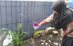 Salah seorang warga sedang menyiram kuburan Tembuni cucunya yang dibantu oleh Ika pada tahun 2019 lalu di Desa Pagerwangi, Kecamatan Lembang, Kabupaten Bandung Barat. (3/11/2025) (Sumber: Dokumentasi Penulis | Foto: Azzahra Nadhira)