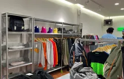 Pengunjung PAPER menikmati suasana toko yang menampilkan koleksi busana kasual berwarna mencolok pada rak dan gantungan pakaian (28/10/2025) (Foto: Malik)