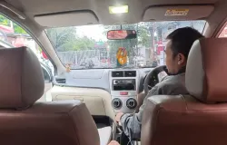 Seorang&nbsp;driver online&nbsp;tengah tersenyum ramah menunggu penumpangnya di tengah keramaian jalanan, menerapkan nilai&nbsp;cageur, bager, bener&nbsp;dalam layanan transportasi – Bandung, Sabtu (01/11/2025) (Foto: Bunga Kemuning A.D)