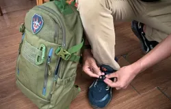 Dyvo Xavier Muhamad Yandi Putra sedang mengikat tali sepatunya sambil membawa tas ransel Cartenz Tactical di sampingnya .(Foto: Patricia Avrilia Rolina)