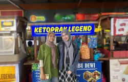 Gambar 1.1 Karyawan Ketoprak Legend Bu Dewi menyambut pembeli di depan gerobak biru khas mereka (28/10/2025). (Sumber: Dokumentasi pribadi penulis | Foto: Syakirah Salsabila)