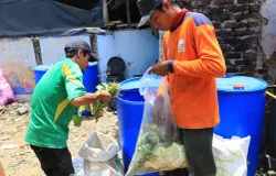 Petugas memasukan sampah organik ke dalam drum komposter di Pasar Sederhana, Kota Bandung, Selasa 15 Oktober 2024. (Sumber: Ayobandung.id | Foto: Irfan Al-Faritsi)