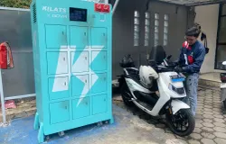 Rizki Ahmad sedang melakukan pengisian baterai motor listrik di Kantor Pos Ujung Berung Kota Bandung, pada Kamis, 9 April 2026. (Sumber: ayobandung.id | Foto: Toni Hermawan)