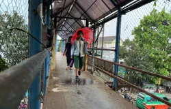 Pelejar berjalan di JPO di Jalan Amir Machmud, perbatasan Kota Bandung dan Cimahi, Jumat, 10 April 2026. (Sumber: ayobandung.id | Foto: Ilham Maulana)