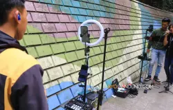 Konten kreator TikTok bernyanyi secara daring menggunakan smartphone (telepon pintar) di Jalan Babakan Siliwangi, Kota Bandung (Sumber: Ayobandung.com | Foto: Irfan Al-Faritsi)