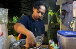 Berjualan cilok menjadi sumber penghasilan utama Raja, di sela kegiatannya mengelola lapak baca sederhana di pinggir jalan. (Sumber: ayobandung.id | Foto: Ilham Maulana)