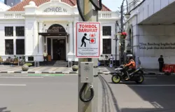 Pengguna jalan melintas di dekat satu tombol darurat (panic button) yang dipasang di Jalan Asia Afrika, Kota Bandung, Rabu 26 November 2025. (Sumber: Ayobandung.id | Foto: Irfan Al-Faritsi)