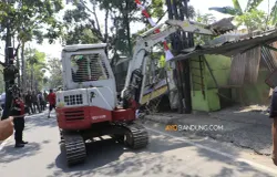 Petugas Satpol PP Kota Bandung menggunakan alat berat merobohkan bangunan liar dan lapak PKL di Jalan Ibrahim Adjie, Kiaracondong, Kota Bandung, Senin 10 Agustus 2026. (Sumber: ayobandung.com | Foto: Irfan Al-Faritsi)