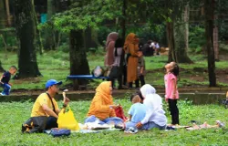 Warga memanfaatkan ruang terbuka hijau di Kebun Binatang Bandung untuk bersantai dan makan bersama. (Sumber: ayobandung.id | Foto: Irfan Al Farisi)