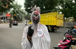 Cosplayer pocong di Lembang memanfaatkan QRIS untuk menerima uang dari warga. (Sumber: ayobandung.id | Foto: Halwa Raudhatul)