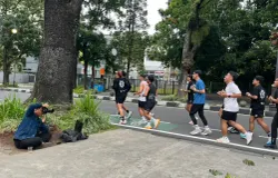 Seorang fotografer mengabdikan para pelari di daerah Dago, Kota Bandung. (Sumber: ayobandung.id | Foto: Ilham Maulana)