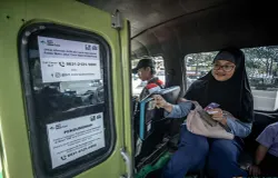 Penumpang feeder Metro Trans Jabar sedang membayar ongkos menggunakan mesin tapcash. (Sumber: ayobandung.id | Foto: Kavin Faza)
