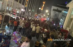 Warga berlalu lalang di kawasan Asia Afrika, Kota Bandung, pada malam hari. (Sumber: ayobandung.com | Foto: Ditya Rafi Muttaqin/Magang)