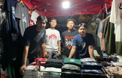 Jujun melayani pembeli di lapak kaos di Jalan Trunojoyo, Kota Bandung, saat mencoba peruntungan berjualan untuk pertama kali menjelang Lebaran dengan menawarkan promo dua kaos seharga Rp100 ribu. (Sumber: ayobandung.id | Foto: Ilham Maulana)