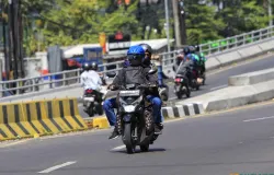 Pemudik sepeda motor melintasi jalur utama di Kota Bandung dengan membawa barang bawaan saat mudik Lebaran. (Sumber: ayobandung.id | Foto: Irfan Al Faritsi)