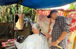 Yana Mulyana dengan ruang ala kadarnya tetap bertahan di bawah rindang pohon Jalan Malabar, Kota Bandung. (Sumber: ayobandung.id | Foto: Ilham Maulana)