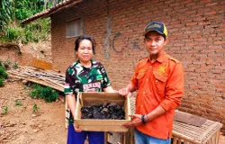 Iman Romansyah (baju orange), KAUR Umum Tata Usaha dan Koordinator BUMDes Margamukti, Sumedang, bersama seorang warga peternak ayam, (22/5/2026). (Sumber: Ayobandung.id | Foto: Aris Abdulsalam)