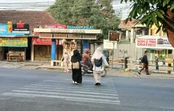 Pejalan kaki yang menyeberang di zebra cross depan gerbang pintu masuk-keluar UIN Bandung Kampus 1. Difoto pada hari Rabu, 7 Oktober 2026 pukul 06.26 WIB. (Sumber: Dok. Pribadi | Foto: Evira Dwi Shakira)