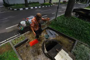 Warga mengambil air sumur yang berada di trotoar Jalan Cipaganti, Kelurahan Pasirkaliki, Kecamatan Cicendo, Kota Bandung. (Sumber: Ayobandung | Foto: Irfan Al Faritsi)