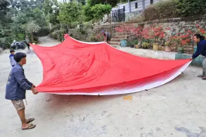 Warga membentangkan bendera Merah Putih raksasa berukuran 10x18 meter sebagai persiapan pengibaran pada 17 Agustus 2026 di Tebing Gunung Hawu. (Sumber: Ayobandung.com | Foto: Irfan Al-Faritsi)