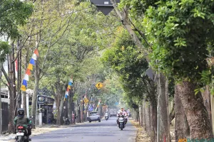 Pengendara melintasi jalan Pacuan Kuda Arcamanik pada Rabu, 19 Agustus 2026. Tampak jalan tersebut teduh karena masih ditumbuhi pohon-pohon berukuran besar. (Sumber: ayobandung.id | Foto: Irfan Al Faritsi)