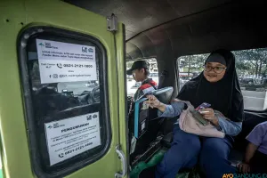 Penumpang feeder Metro Trans Jabar sedang membayar ongkos menggunakan mesin tapcash. (Sumber: ayobandung.id | Foto: Kavin Faza)
