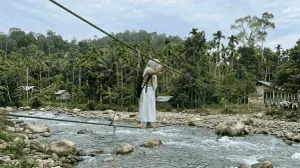 Seorang anak sekolah di Aceh yang menyebrangi jembatan tali menuju sekolah. (Sumber: Generated AI (Terinspirasi dari Video Asli di Aceh))