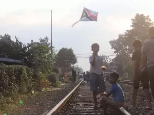 Anak-anak bermain layangan di atas rel kereta api Jalan Laswi (Sumber: Ayobandung.com | Foto: Irfan Al-Faritsi)