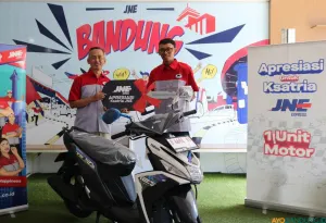 Kepala Cabang Utama JNE Bandung Iyus Rustandi menyerahkan bantuan sepeda motor baru kepada Hasan sebagai bentuk nyata komitmen dan kepedulian perusahaan terhadap keselamatan karyawannya. (Sumber: ayobandung.id | Foto: Arif Budianto)