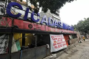 Sejumlah spanduk penolakan pembangunan jalur BRT yang dipasang oleh para pedagang terlihat di depan lapak PKL, Jalan Ahmad Yani, Cicadas, Kota Bandung, (17/12026). (Sumber: Ayobandung.com | Foto: Irfan Al-Faritsi)