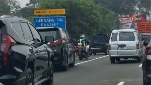 Rombongan kendaraan menembus antrean keluar Gerbang Tol Pasteur dengan bantuan pengawalan polisi. (Sumber: Dok. Penulis)