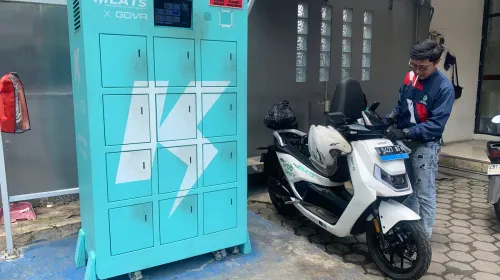Rizki Ahmad sedang melakukan pengisian baterai motor listrik di Kantor Pos Ujung Berung Kota Bandung, pada Kamis, 9 April 2026. (Sumber: ayobandung.id | Foto: Toni Hermawan)