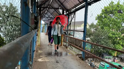 Pelejar berjalan di JPO di Jalan Amir Machmud, perbatasan Kota Bandung dan Cimahi, Jumat, 10 April 2026. (Sumber: ayobandung.id | Foto: Ilham Maulana)