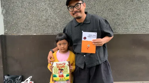 Herry Prihamdani datang bersama anaknya, mengenalkan kebiasaan membaca sejak dini sambil menikmati ketenangan dalam suasana baca senyap. (Sumber: ayobandung.id | Foto: Halwa Raudhatul)