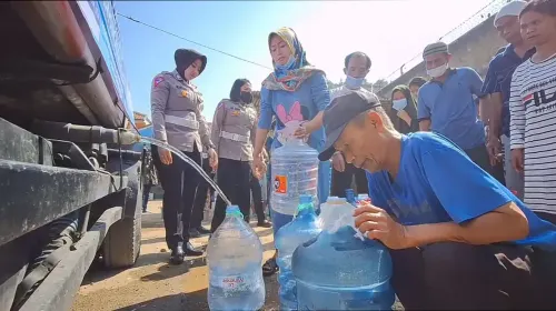 Sejumlah warga Bandung, dibantu sanggota Satlantas Polresta Bandung, sedang antre air bersih.
sedang mengantre air bersih, (Sumber: ayobandung.com | Foto: Mildan Abdalloh)