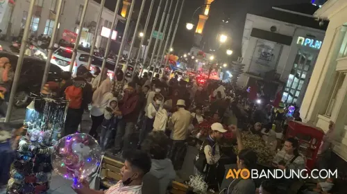 Warga berlalu lalang di kawasan Asia Afrika, Kota Bandung, pada malam hari. (Sumber: ayobandung.com | Foto: Ditya Rafi Muttaqin/Magang)