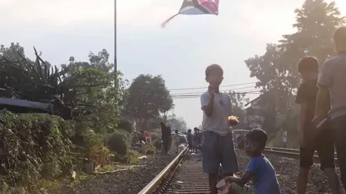 Anak-anak bermain layangan di atas rel kereta api Jalan Laswi (Sumber: Ayobandung.com | Foto: Irfan Al-Faritsi)