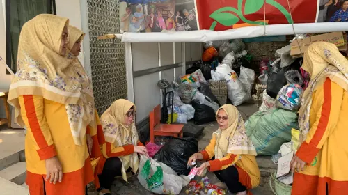 Pengelola Bank Sampah Ikhtiar 15 Jatihandap, Kota Bandung, mencatat hasil timbangan sampah warga yang nantinya dapat dikonversi menjadi tabungan emas. (Sumber: ayobandung.id | Foto: Halwa Raudhatul)