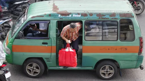 Warga hendak turun dari angkot. (Sumber: ayobandung.com | Foto: Irfan Al-Faritsi)