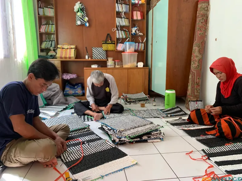 Abang Oyong yang sudah memasuki usia 80-an membantu membuat karpet hasil olahan sampah di Komunitas Masagi Tjibogo. (Sumber: ayobandung.id | Foto: Halwa Raudhatul)