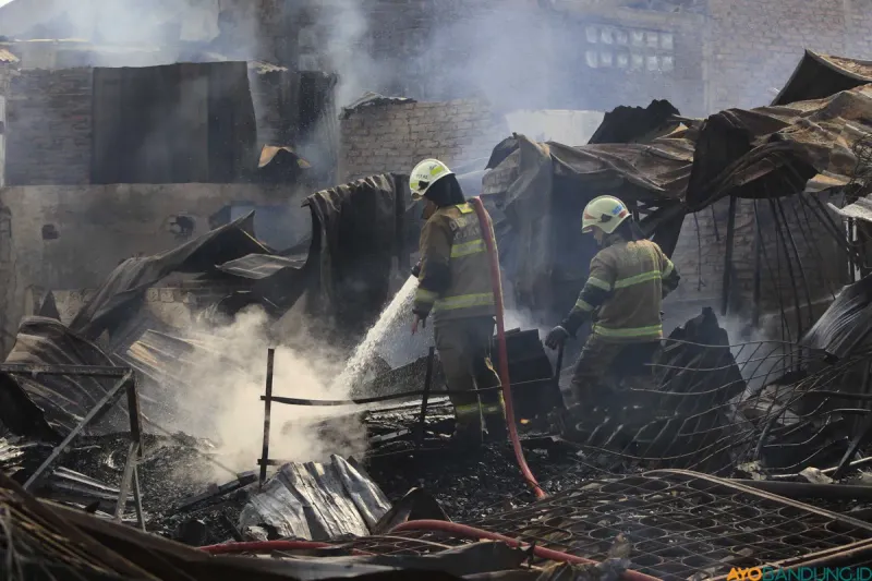 Petugas Pemadam Kebakaran dan Penyelamatan Kota Bandung melakukan pendinginan pada kios material barang bekas yang terbakar di Jalan Soekarno-Hatta, Kota Bandung, Kamis 26 Maret 2026. (Sumber: ayobandung.id | Foto: Irfan Al Faritsi)