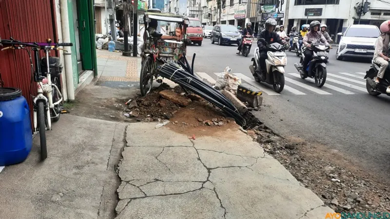 Pengendara di Jalan Otista Kota Bandung melintas di samping galian kabel yang tidak ditutup semestinya, Jumat (27/2). Kondisi ini membahayakan pengguna jalan. (Sumber: ayobandung.id | Foto: Nisrina Nuraini)