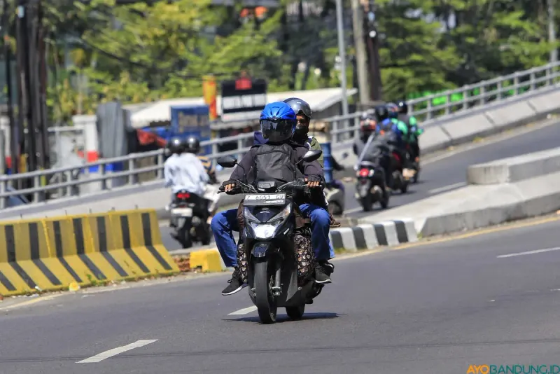 Pemudik sepeda motor melintasi jalur utama di Kota Bandung dengan membawa barang bawaan saat mudik Lebaran. (Sumber: ayobandung.id | Foto: Irfan Al Faritsi)